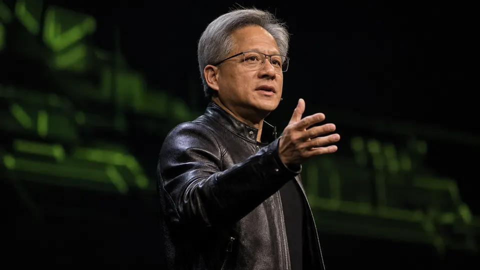 Illustrative photo of Nvidia CEO Jensen Huang speaking on a keynote stage under warm spotlights.
