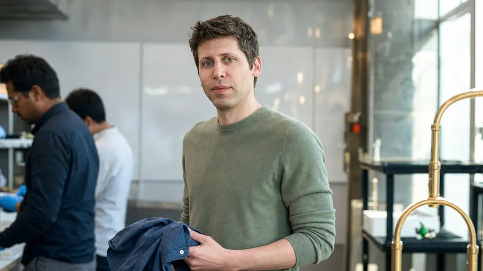 Illustrative photo of Sam Altman in a research lab, holding a shirt and looking toward the camera.